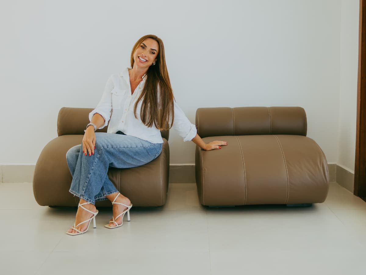 Nicole Bahls sentada em uma das poltronas Conquista